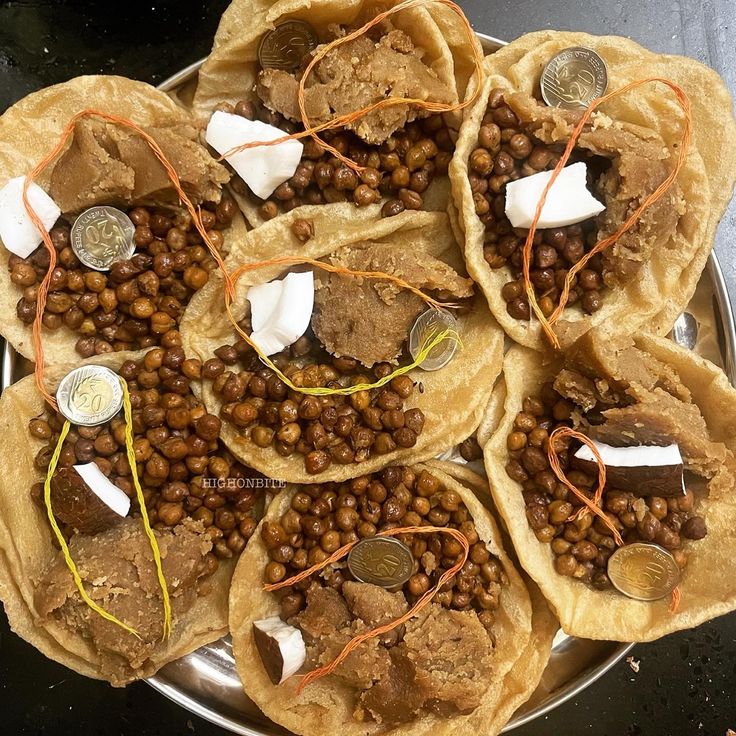 several pita breads filled with beans and other food items on a silver plate