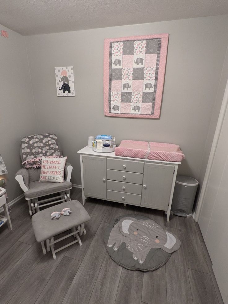 a baby's room with gray and pink decor