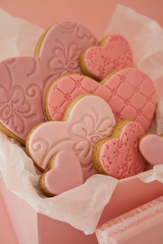 heart shaped cookies are in a pink box