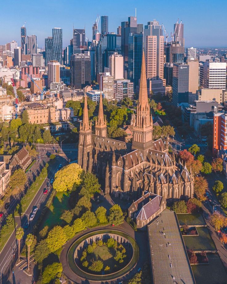 an aerial view of a city with cathedrals and trees in the foreground, surrounded by tall buildings