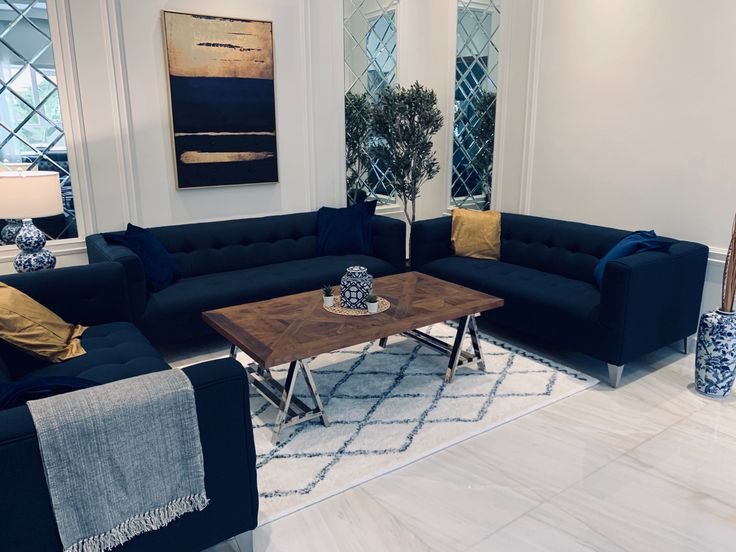 a living room filled with blue couches next to a coffee table and vases