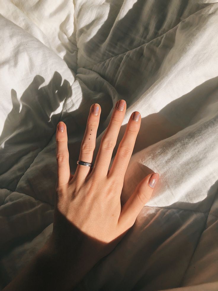 a person's hand on top of a white sheet with their fingers extended out