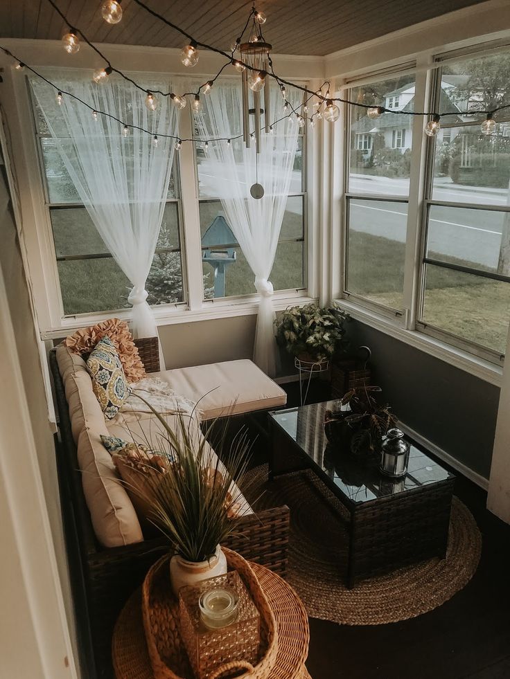 a living room with couches, tables and lights hanging from the ceiling above them