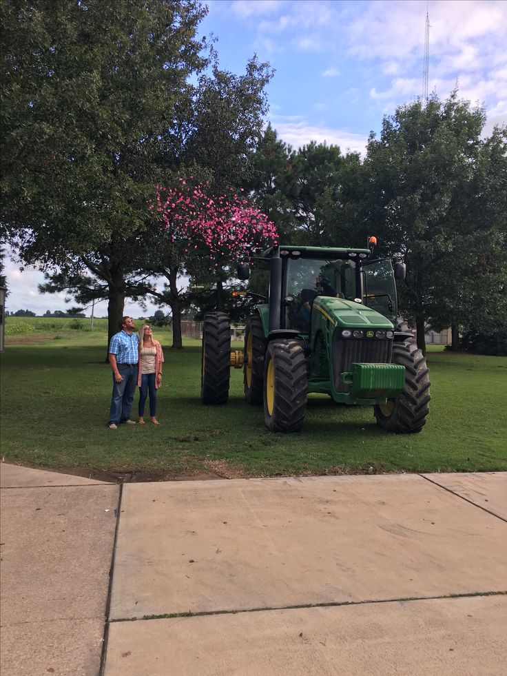 two people standing in front of a tractor