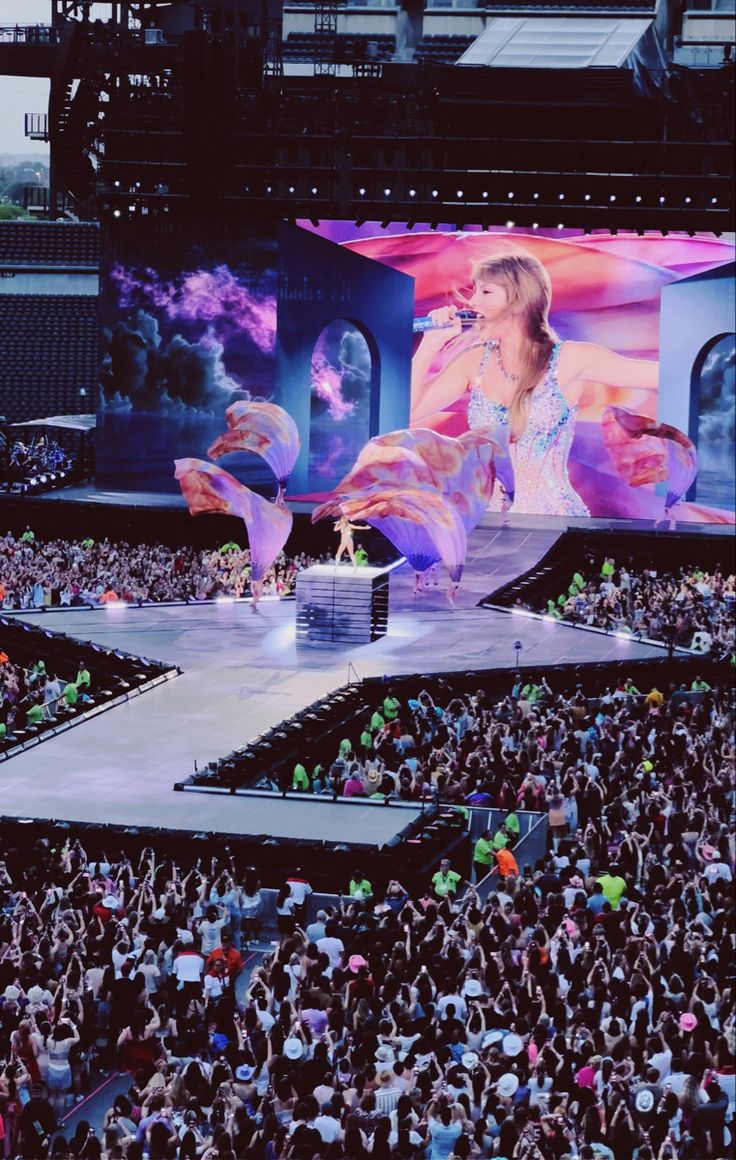 a large group of people standing on top of a stage in front of a crowd