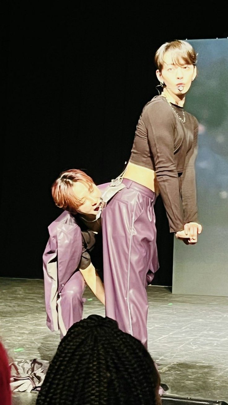 two people are performing on stage with one holding the other's leg in front of him