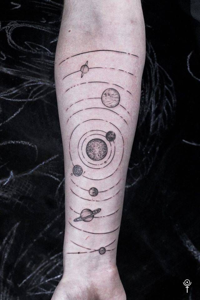 a person with a tattoo on their arm that has planets and stars in the sky