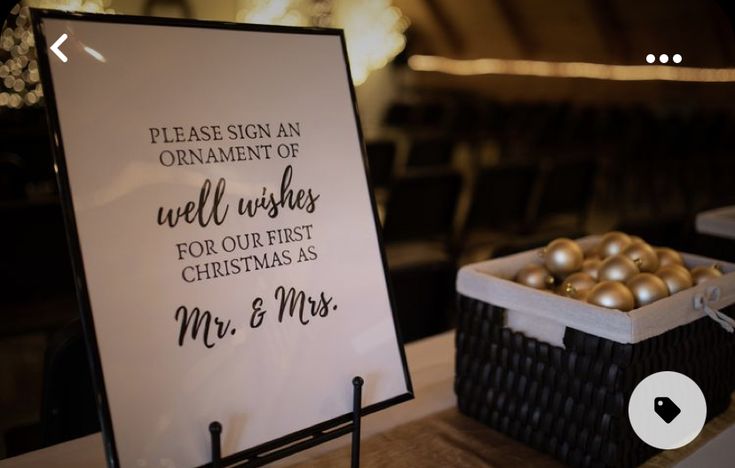 a sign sitting on top of a table next to a basket filled with gold balls