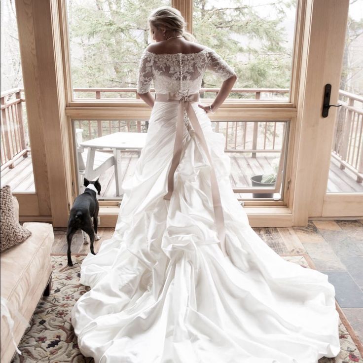 a woman standing in front of a window next to a dog