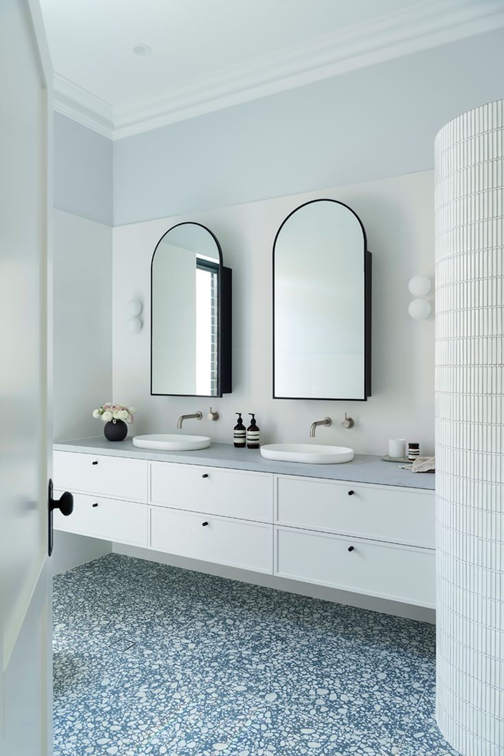 two sinks and mirrors in a white bathroom