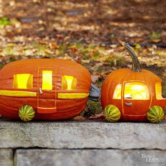 two pumpkins with faces carved into them sitting on the ground