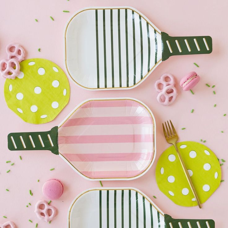 pink and green plates with white polka dots on them are arranged in the shape of utensils