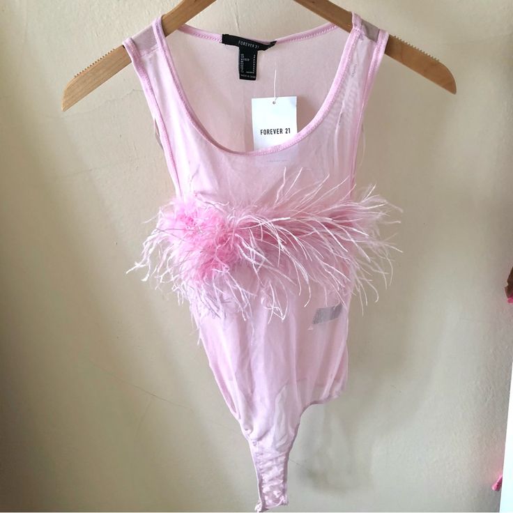 a pink dress hanging on a hanger in front of a wall with a sign