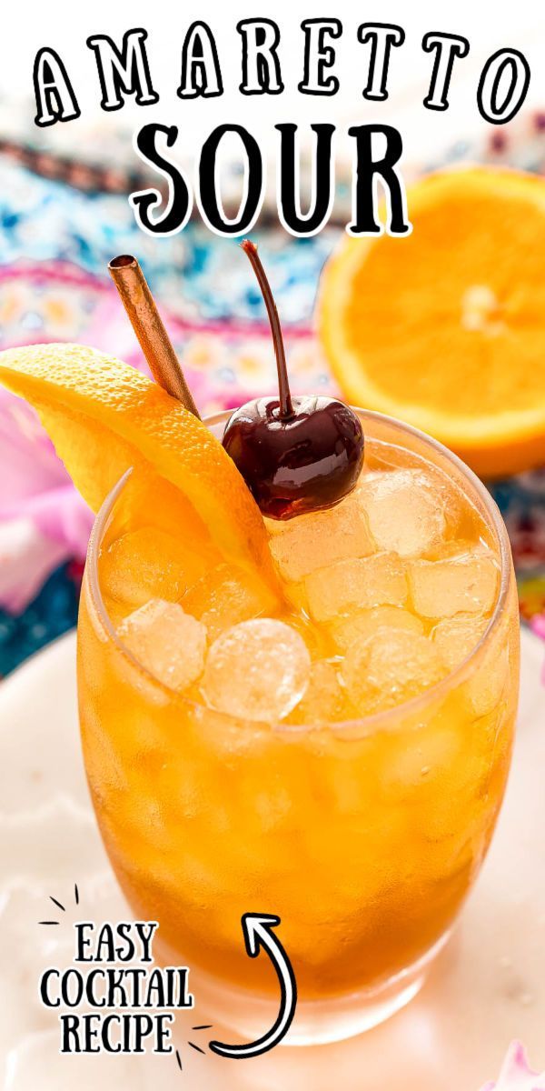 an orange drink in a glass with ice and garnish on the rim that says amaretto sour