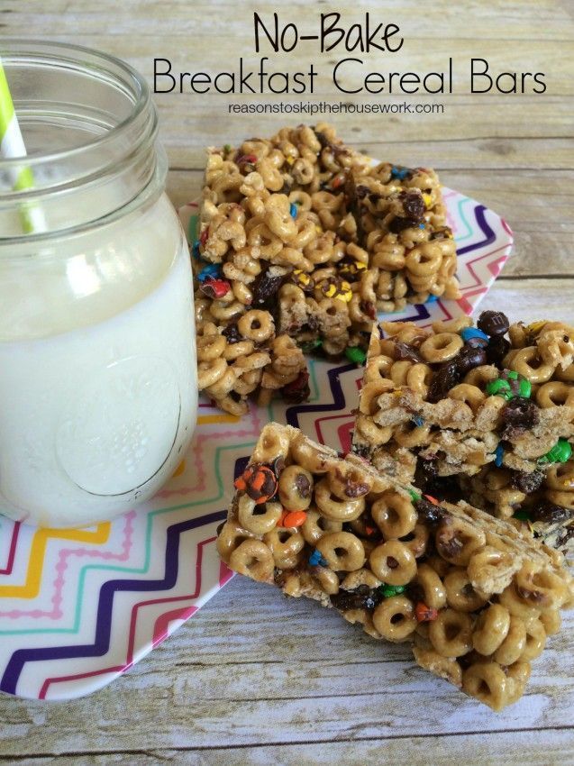 some cereal bars are on a plate next to a glass of milk and a jar