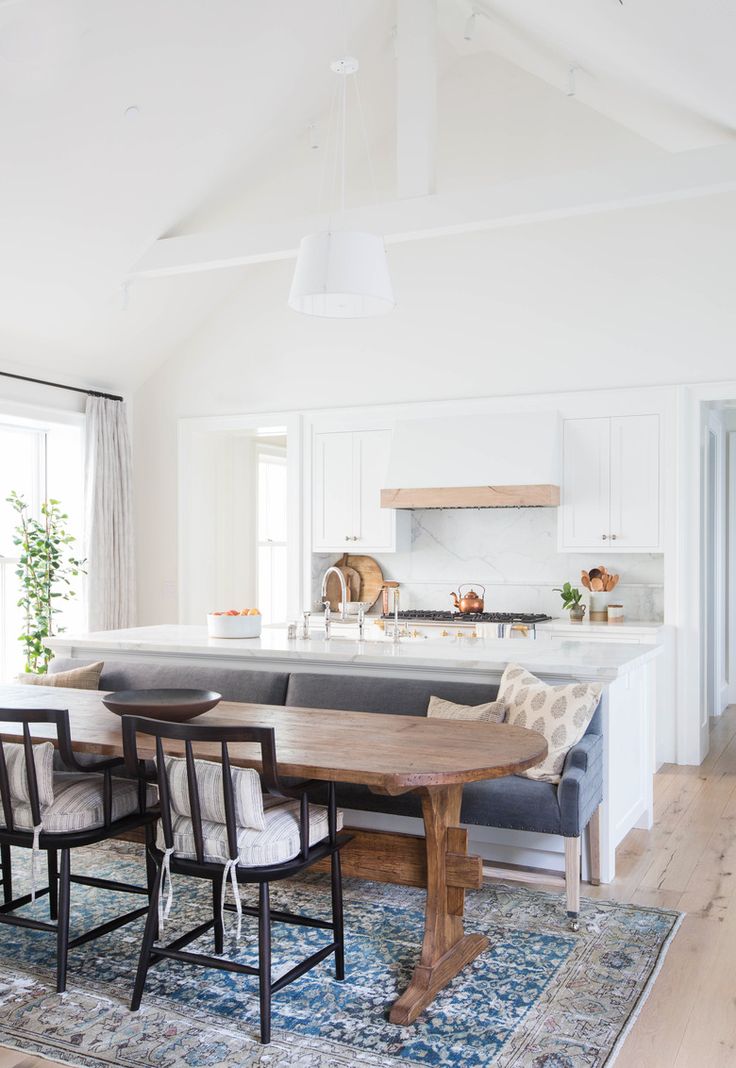 a dining room table and chairs in front of an island