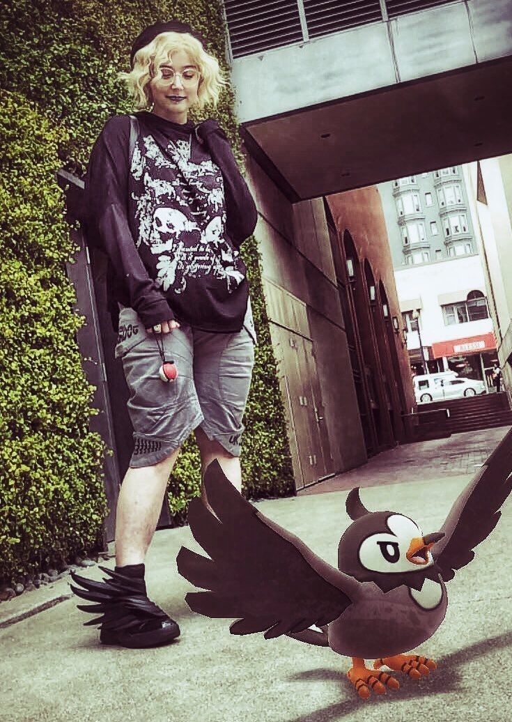 a woman standing next to an angry bird statue