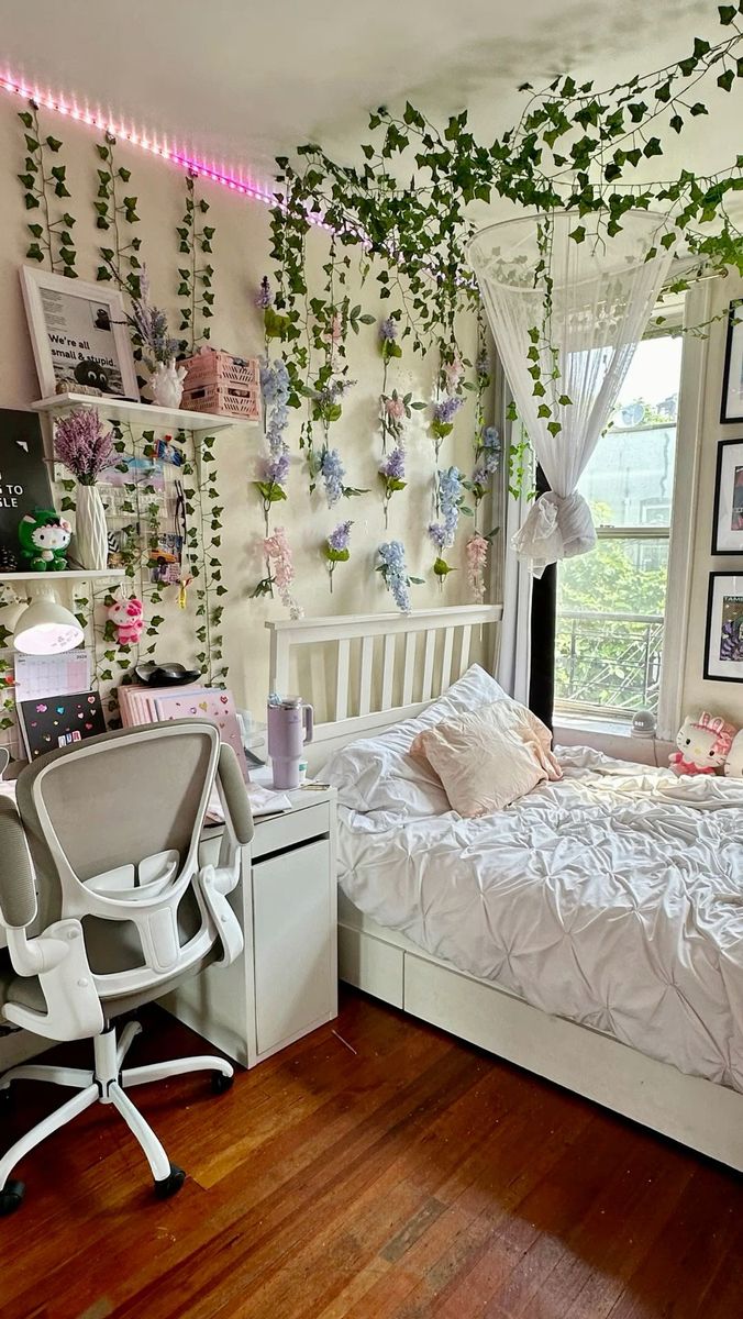 a bedroom decorated in white and pink with hanging plants on the wall above the bed