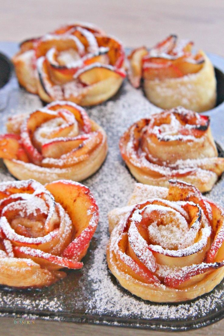 pastries with powdered sugar on them sitting in a pan