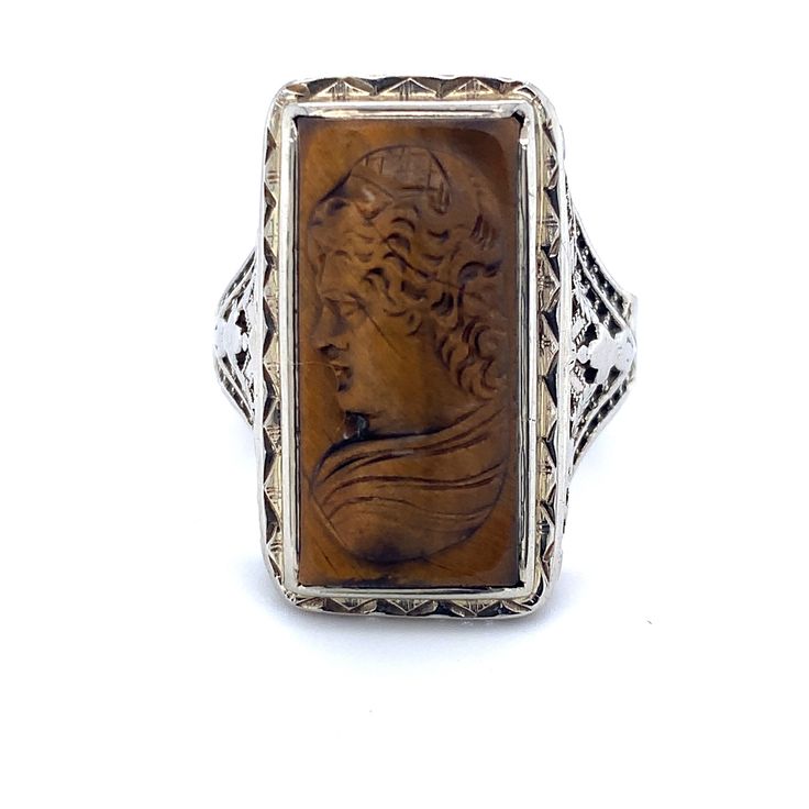 All of our jewelry is guaranteed authentic by our Graduate Gemologist of the Gemological Institute of America (GIA). 14k White Gold Filigree Genuine Natural Tiger's Eye Cameo Ring (#J4989) Art Deco 14k white gold filigree ring featuring a carved tiger's eye quartz cameo. The tiger's eye stone measures about 19.1mm x 10mm. The ring fits a size 5 3/4 finger. It weighs 3.2 dwt., and dates from the 1920's. Fantastic! Inv#RZ5350. SKU#J4989. 100% Satisfaction Guaranteed! Antique Carved Sterling Silver Signet Ring, Antique Sterling Silver Intaglio Jewelry, Antique Engraved Sterling Silver Ring, Antique Carved Sterling Silver Engraved Ring, Antique Carved Filigree Ring For Formal Occasions, Ornate Intaglio Jewelry For Anniversary, Formal Oval Carved Filigree Ring, Vintage Carved Filigree Ring For Formal Occasions, Antique Carved Filigree Ring