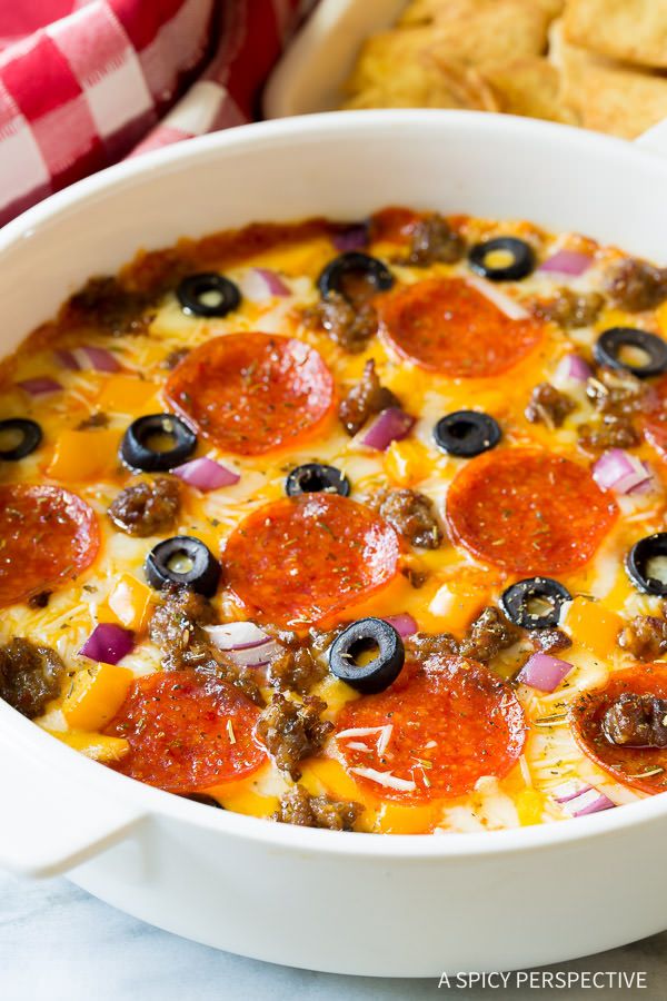 a white casserole dish filled with pepperoni and olives