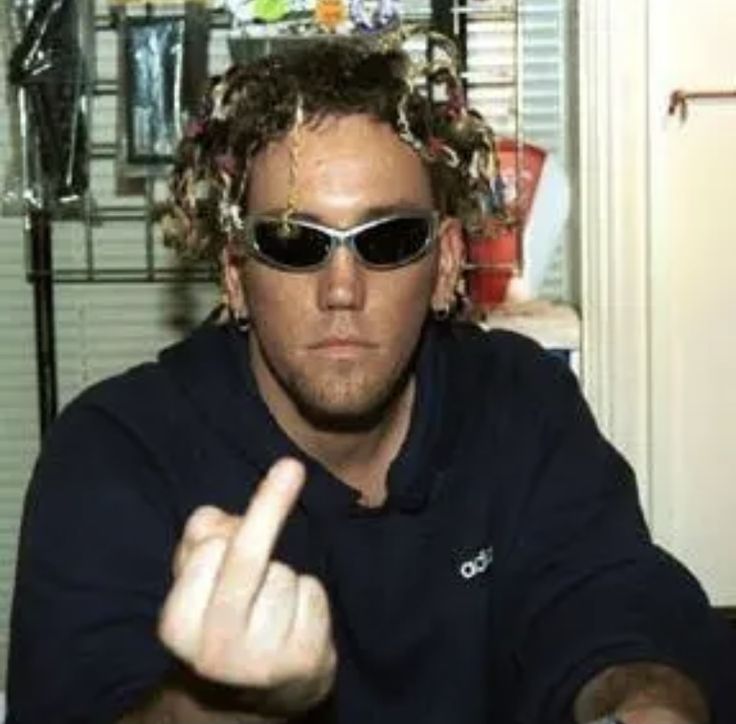 a man wearing sunglasses and pointing at the camera with his fingers in front of him