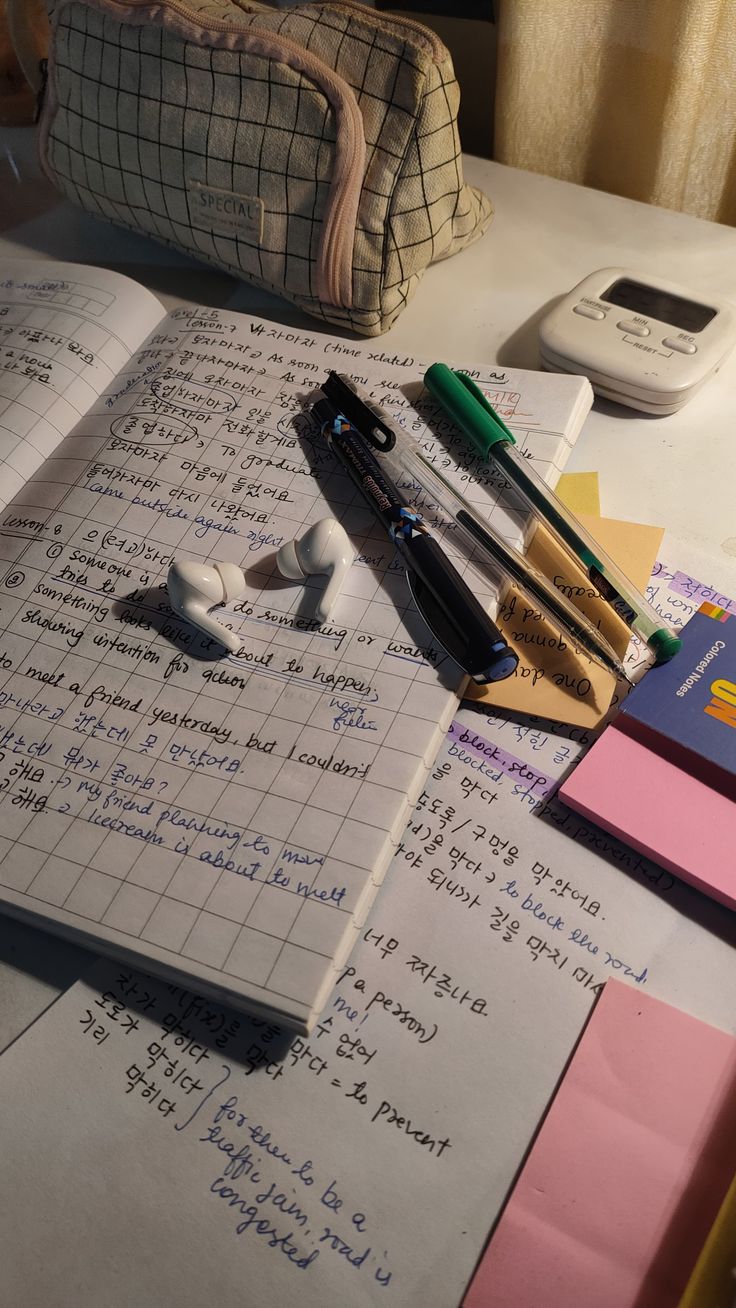 an open notebook sitting on top of a table next to pens and other office supplies