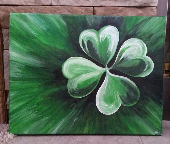 a painting of a four leaf clover on a green and white background in front of a brick wall