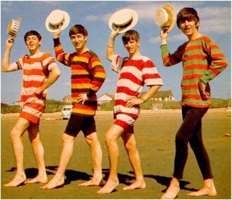 four young men in striped shirts holding up hats