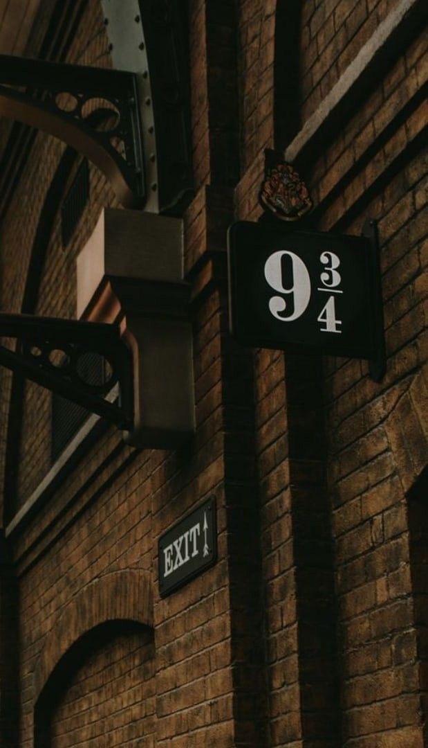 an exit sign is attached to the side of a brick building with arched doorways