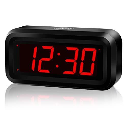 an alarm clock with red numbers on the display is shown in front of a white background