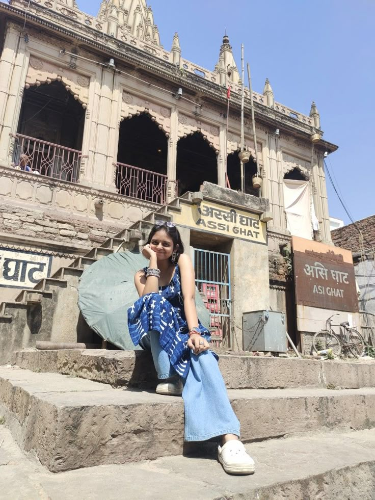 a woman sitting on steps in front of an old building