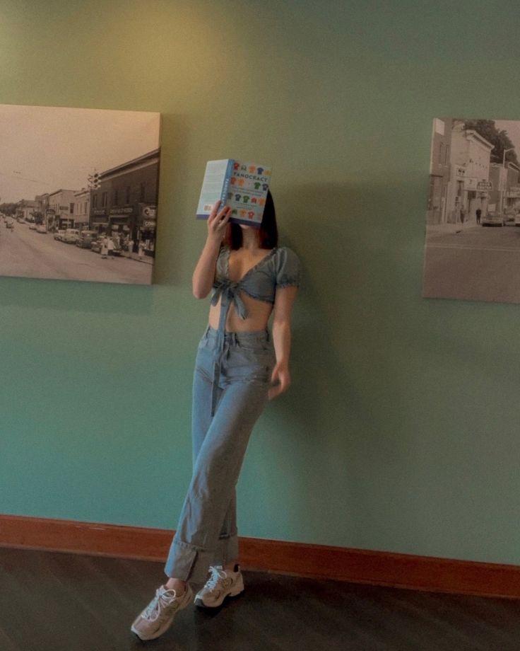 a woman standing in front of a wall with a box on her head