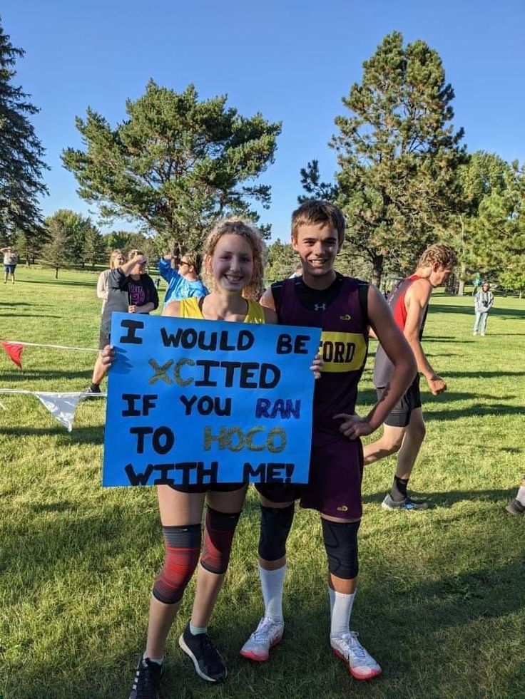 two people standing next to each other holding a sign that says if would be victim if you ran to hog with me