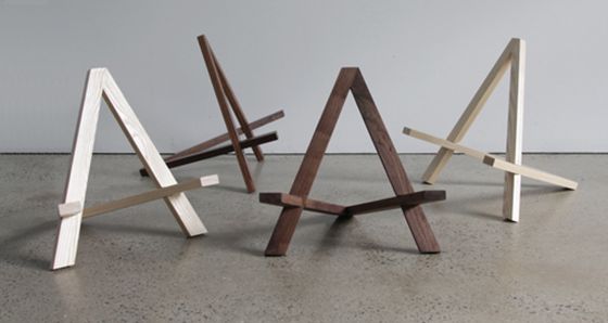 three pieces of wood sitting on top of a cement floor in front of a white wall