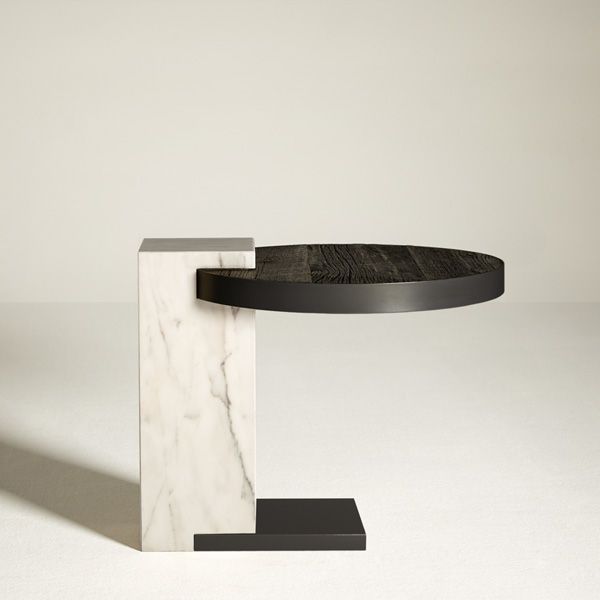 a white marble and black metal table with an oval shaped top on the base, against a plain background