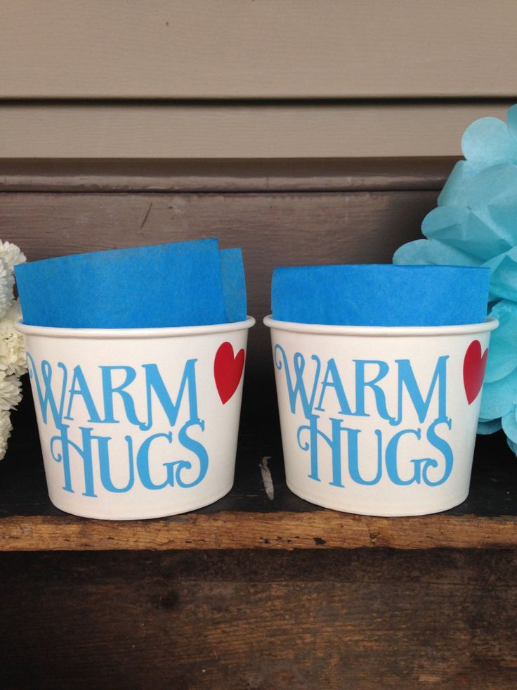 two blue and white buckets with the words warm hugs written on them next to a teddy bear