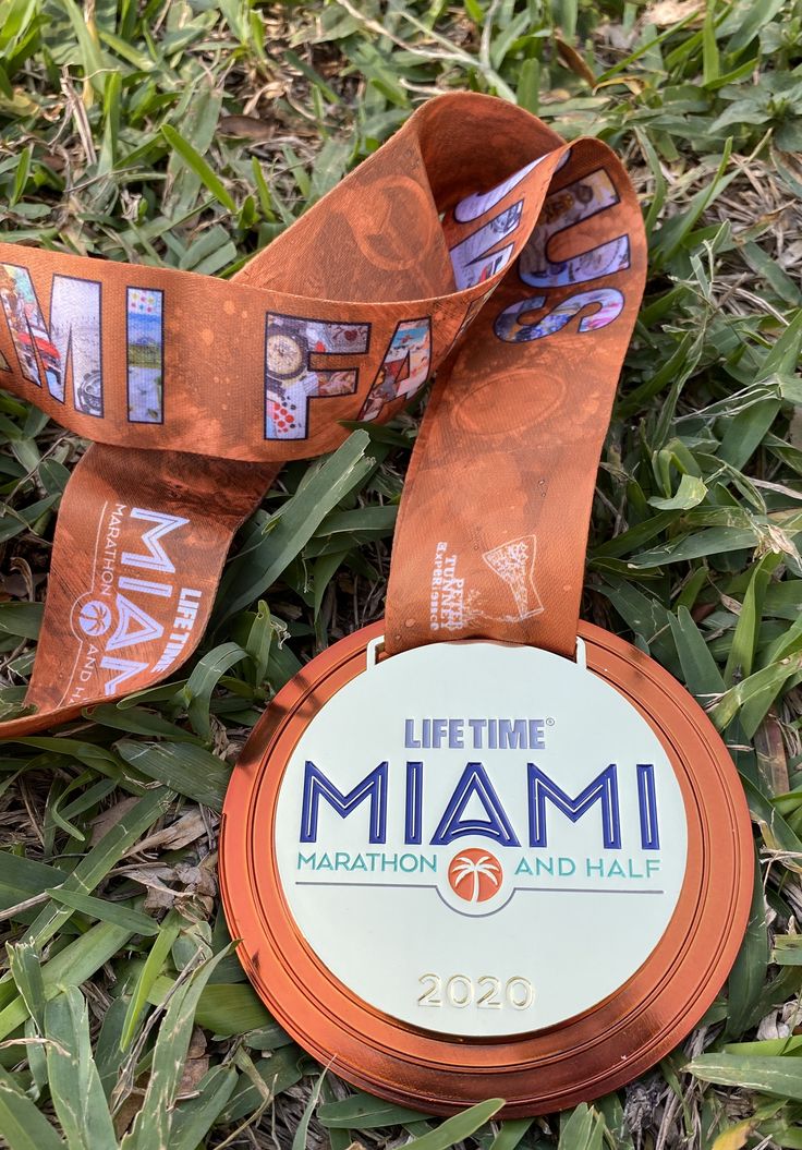 a medal laying in the grass with a ribbon around it