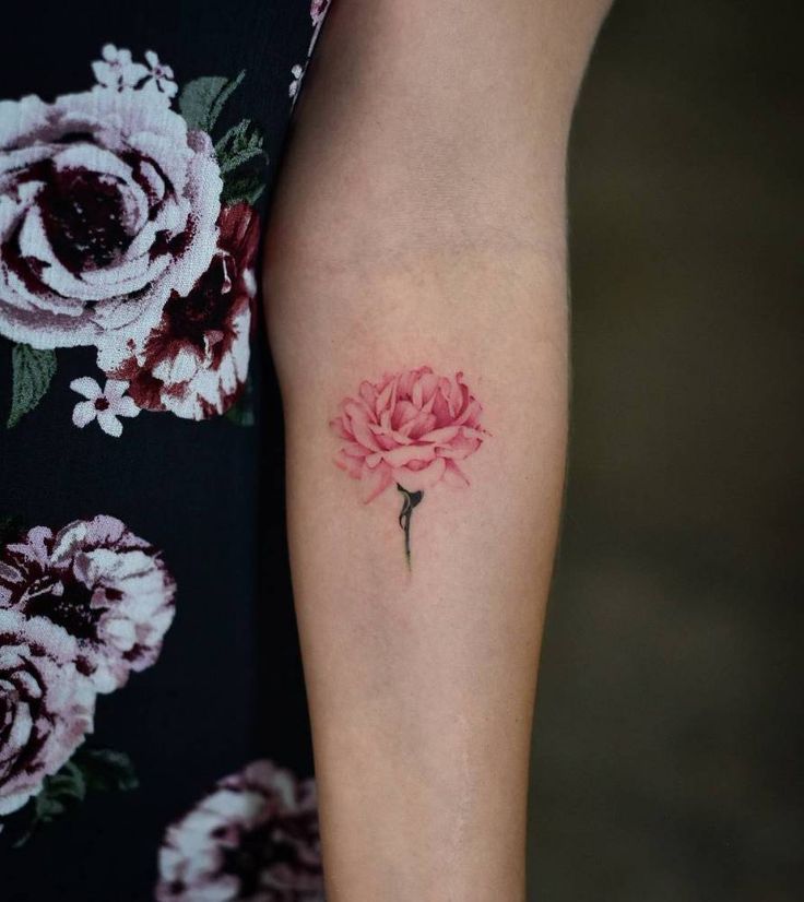 a woman's arm with a pink flower tattoo on the left side of her body