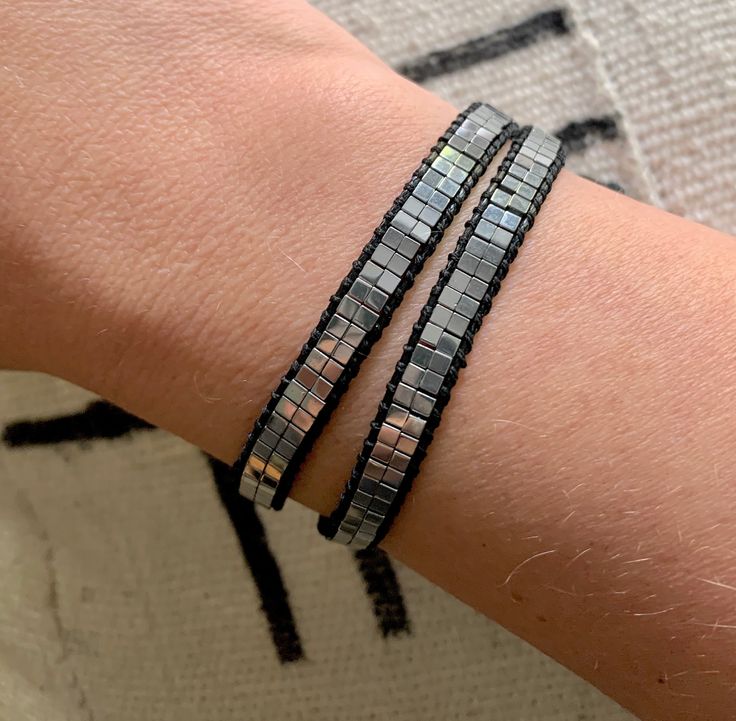 Add interest and style to any outfit with this eye-catching wrap bracelet. Features Silver Hematite Gemstone Beads with lots of sheen. Easily wraps around the wrist twice with a silver button closure. Several button holes for a customized fit on any wrist. No guesswork on sizing, making this a great gift! Total length is 17 inches. {Hematite is a natural gemstone with a metallic look and feel} Adjustable Nickel-free Modern Beaded Bracelets, Silver Beaded Bracelets With Faceted Beads For Festivals, Bohemian Silver Wrap Bracelet With Faceted Beads, Modern Adjustable Silver Wrap Bracelet, Modern Silver Bracelet With Black Beads, Modern Silver Beaded Bracelet With Black Beads, Silver Beaded Wrap Bracelet For Festivals, Silver Hand Wrapped Beaded Bracelets For Party, Adjustable Silver Modern Beaded Bracelets