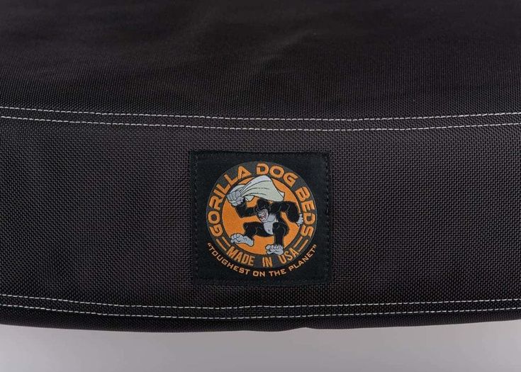 the back side of a black bag with an orange and white patch on it's front