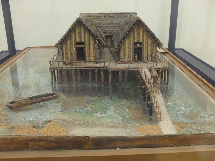 a model of a house in a glass case with water and debris on the ground