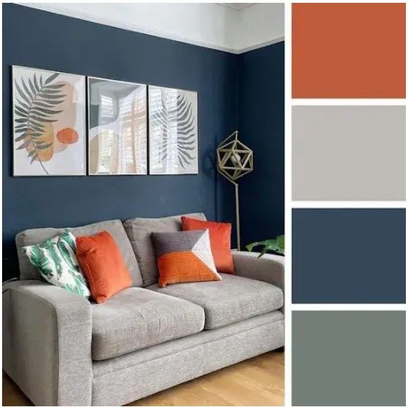 a living room with blue walls, orange and gray pillows on the couches in front of them