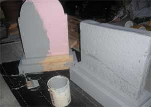 a cup is sitting on the floor next to a gravestone that has been painted pink