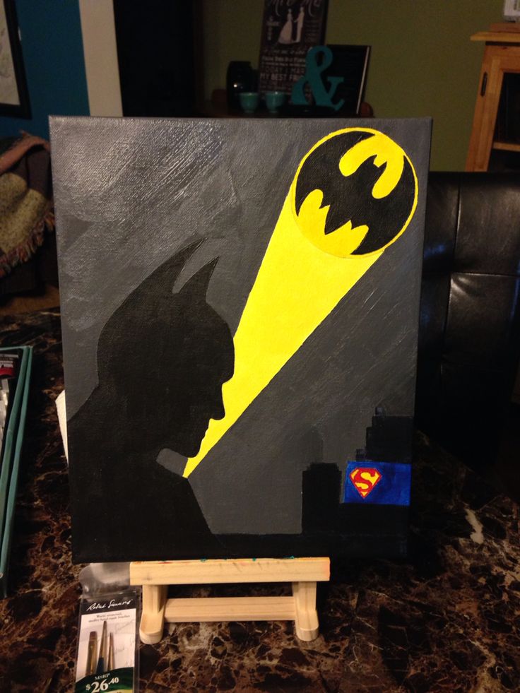 a batman silhouette painted on a canvas in the shape of a man's head