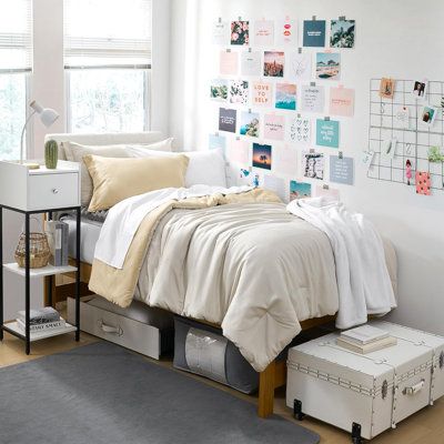 a bedroom with white walls and lots of pictures on the wall