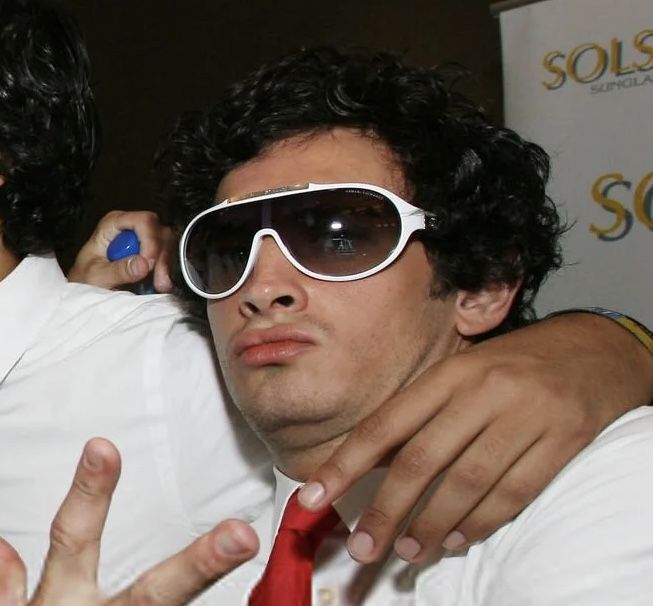 two men in white shirts and red tie posing for the camera with their arms around each other