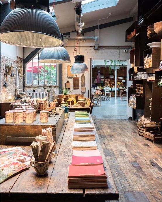 a room filled with lots of different types of items on tables and lamps hanging from the ceiling