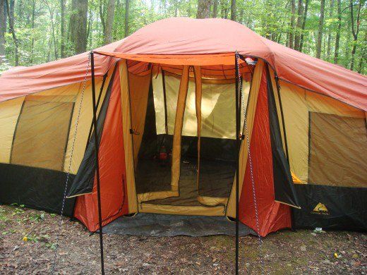 an orange and black tent in the woods