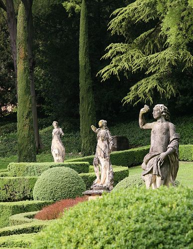 some statues are in the middle of a garden